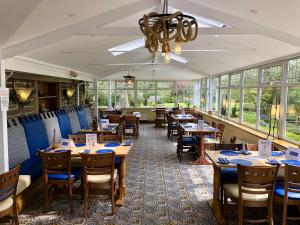 un restaurant avec des tables et des chaises en bois ainsi que des fenêtres dans l'établissement Calf's Head Hotel, à Clitheroe