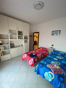 ein Schlafzimmer mit 2 Betten und eine Küche mit Schränken in der Unterkunft Casa Anna in Portoferraio