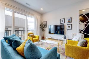 een woonkamer met een blauwe bank en gele stoelen bij Jolene on Main 402 in Nashville