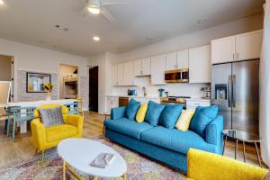 a living room with a blue couch and a kitchen at Jolene on Main 402 in Nashville