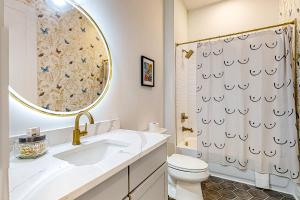 een badkamer met een wastafel, een toilet en een spiegel bij Jolene on Main 402 in Nashville