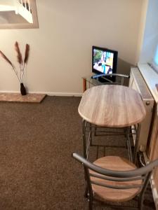 a room with a table and two chairs and a television at 32 Elder Drive Chester CH4 8PD in Chester