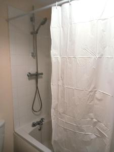 y baño con ducha y cortina de plástico blanco. en 32 Elder Drive Chester CH4 8PD en Chester