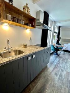 a kitchen with a sink and a counter top at De Stadshoeve in Medemblik