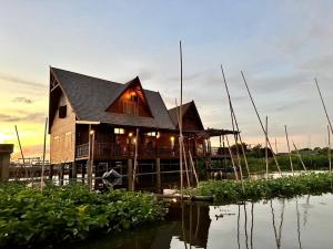 a wooden house on the water next to the water at RuenKijja in Ban Kroen