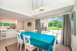 a kitchen and dining room with a blue table and chairs at SWISS 65 - Lake Denise in Clermont