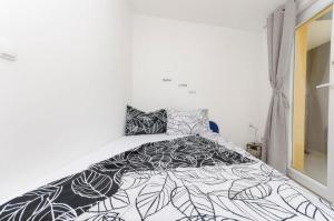 a bedroom with a bed with a black and white comforter at Apartment Tarle in Vodice