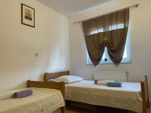 2 camas en una habitación con ventana en Apartments Santa Marija, en Dol