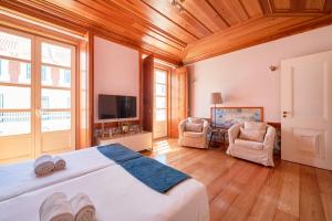 um quarto com uma cama e 2 cadeiras e uma televisão em Casa Portuguesa Prata em Lisboa