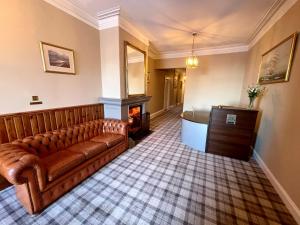 a living room with a couch and a fireplace at Navidale House - Bed, Breakfast & Bar in Helmsdale
