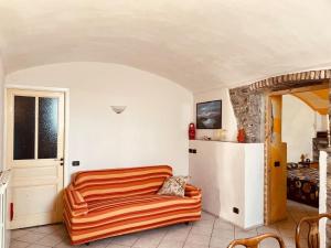 een oranje bank in een kamer met een koelkast bij La Tuga appartamento stile marinaro sul mare in Imperia