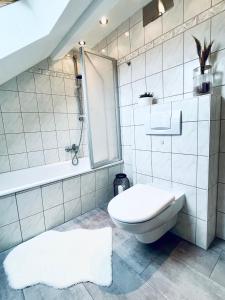 a white bathroom with a toilet and a shower at Cityapartment-SmartTV-Kitchen-Car Parking Space-WLAN in Erfurt