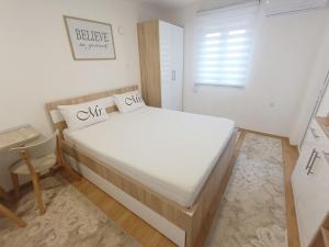 een slaapkamer met een groot wit bed in een kamer bij Apartment SUNSET in Trebinje