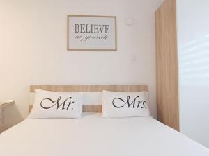 een slaapkamer met een wit bed met 2 kussens bij Apartment SUNSET in Trebinje