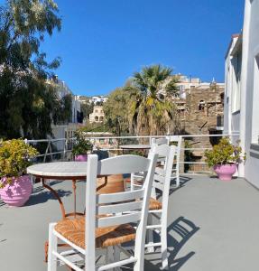 una mesa y 2 sillas sentadas en un balcón en Pallada Boutique Tinos, en Tinos