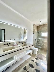 een witte badkamer met een wastafel en een toilet bij Luxurious residence with sea view in Manzanillo