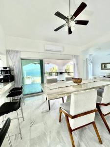 een eetkamer met een plafondventilator en een tafel en stoelen bij Luxurious residence with sea view in Manzanillo
