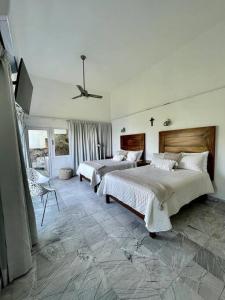 een grote slaapkamer met 2 bedden en een plafondventilator bij Luxurious residence with sea view in Manzanillo