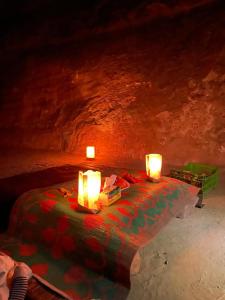 una habitación con dos velas sobre una mesa en una cueva en Wadi rum secrets camp, en Wadi Rum