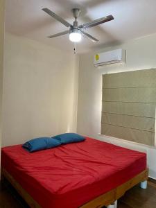 - une chambre avec un lit rouge et un ventilateur de plafond dans l'établissement Hermosa Casa Villas de Cortes en Altata, à Culiacán