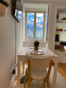 uma pequena mesa branca e cadeira num quarto com uma janela em Sé do Porto no Porto
