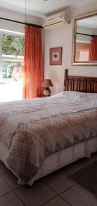 a bedroom with a large bed with a lamp and a window at Indigo Chalets in Port Edward