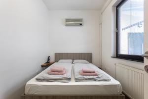 een slaapkamer met een bed met 2 roze kussens erop bij BIG PIPE apartment in Ljubljana