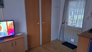 um quarto com televisão e uma porta com janela em Makado em Castillon-en-Couserans