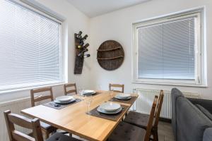 a dining room with a table and chairs and two windows at BIG PIPE apartment in Ljubljana
