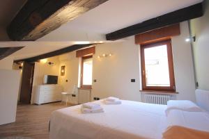 um quarto com uma grande cama branca e uma janela em Case VR Holiday Vittorias Flat em Verona