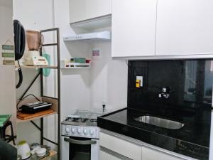 a small kitchen with a sink and a stove at Maceio Ferias apto com varanda vista mar in Maceió