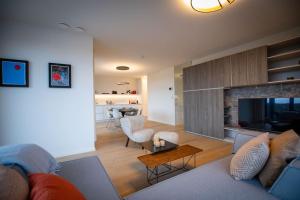 een woonkamer met een bank en een open haard bij Cosy C, light bright and cosy in Cadzand