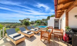 Un patio con tumbonas y una piscina. en Villa Carolina Private Pool, en Agios Nikolaos