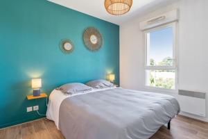 sypialnia z dużym łóżkiem i niebieską ścianą w obiekcie Cosy 40m with terrace in Vannes w mieście Vannes