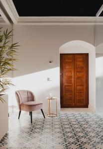 Pokój z krzesłem i drewnianymi drzwiami w obiekcie Sant'Angelo Luxury Resort w mieście Matera