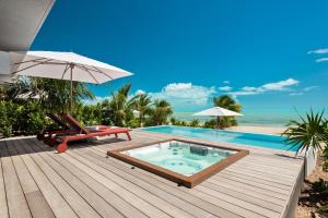 a swimming pool with a hot tub on a wooden deck at Beach Enclave in Providenciales