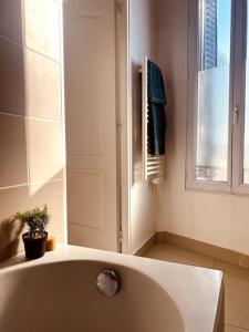 een badkamer met een wit bad en een raam bij Proche Paris-Calme-Wifi-Netflix in Villejuif
