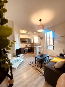 een woonkamer met een bank en een tafel bij Proche Paris-Calme-Wifi-Netflix in Villejuif