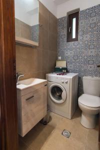 a bathroom with a washing machine and a washer at Papa-Antonis Stone House in Zarós