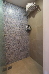 a bathroom with a shower with a tiled wall at Papa-Antonis Stone House in Zarós +32 photos