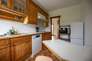 a kitchen with wooden cabinets and a white refrigerator at Cogite in Theux