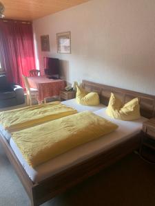 um quarto com 2 camas e almofadas amarelas em Hotel Maien em Todtmoos