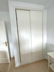 Armario blanco con puerta de cristal en una habitación en Clara Campoamor Seaview Apartment, en Orihuela