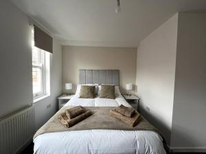 a bedroom with a large bed with two pillows at Ivory House, central modern town house in Leamington Spa