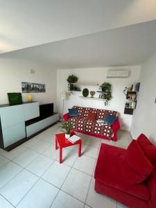 een woonkamer met een rode bank en een rode tafel bij Genova La casa di Saretta in Marina di Ragusa