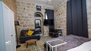 ein Schlafzimmer mit einem Bett, einer Couch und einem Tisch in der Unterkunft Mamila space in Jerusalem