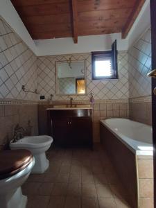 a bathroom with a tub and a toilet and a sink at Il Rifugio in Casertavecchia