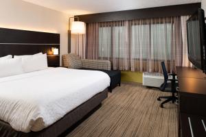 a hotel room with a bed and a flat screen tv at Holiday Inn Express Cincinnati West, an IHG Hotel in Dent