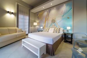 ein Schlafzimmer mit einem großen Bett und einem Sofa in der Unterkunft Matteotti Luxury Residence in Syrakus