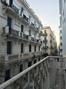 - un ancien bâtiment avec balcon dans une rue de la ville dans l'établissement Appart Central, à Tunis